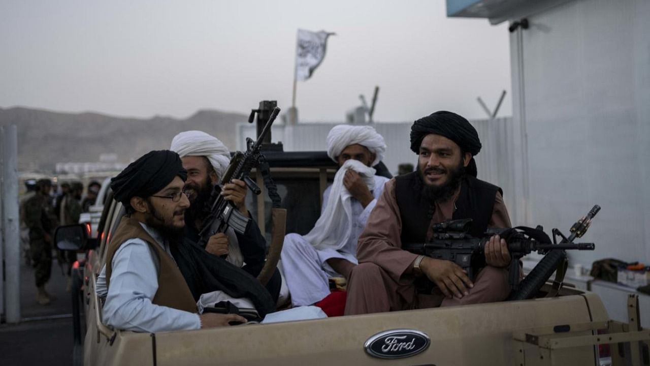  Taliban fighters sit in a pickup truck at the airport in Kabul, Afghanistan. Credit: AFP Photo