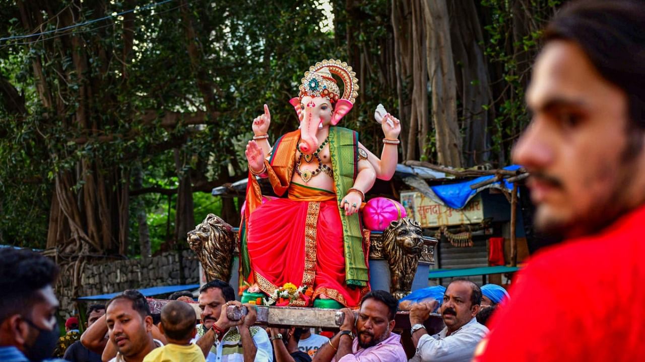 Devotees carry an idol of Lord Ganesha ahead of the Ganesh Chaturthi fetival, at Lalbaug in Mumbai. Credit: PTI Photo