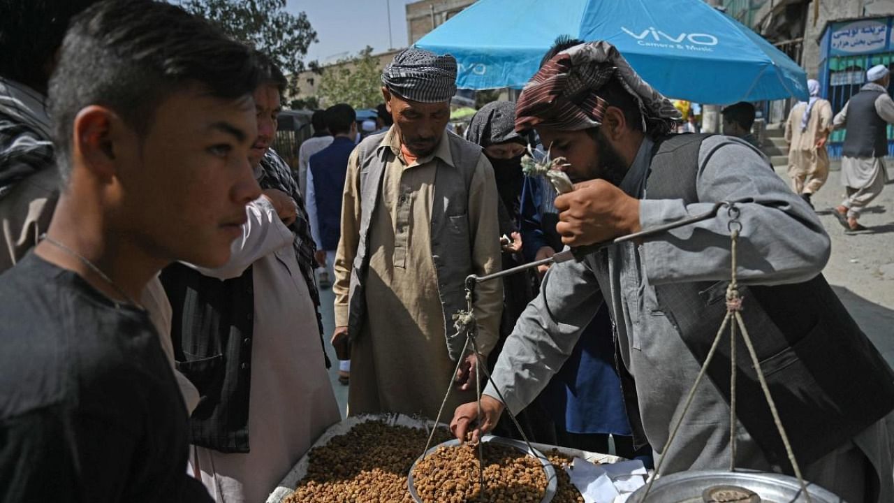 Members of the Hazara community buy dry mulberry at a market on the outskirts of Kabul. Credit: AFP Photo