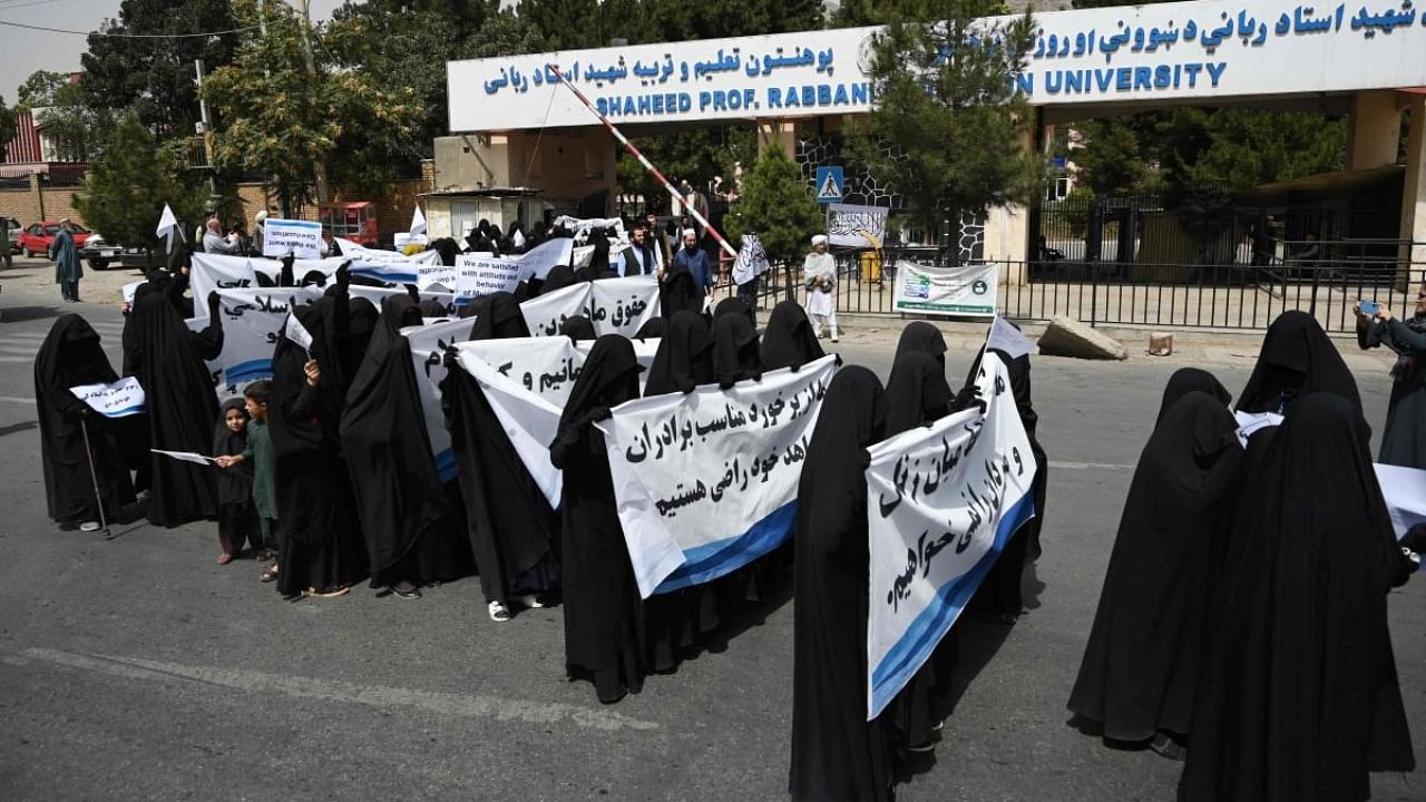 Veiled women hold banners and placards while marching during a pro-Taliban rally outside the Shaheed Rabbani Education University in Kabul. Credit: AFP Photo