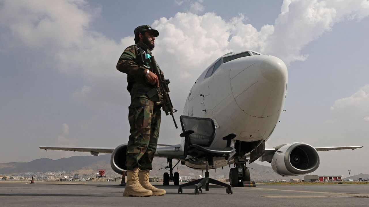 A Taliban fighter stands guard at the Kabul airport. Credit: AFP photo