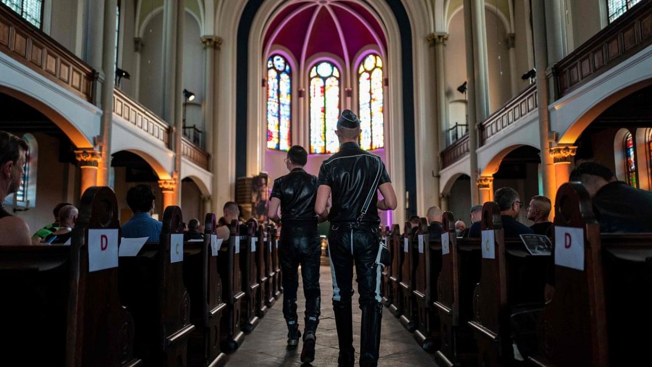 Guests, fully clothed in leather, take their seats at the "Classic meets Fetish" concert at the Twelve Apostles Church in Berlin. Credit: AFP Photo