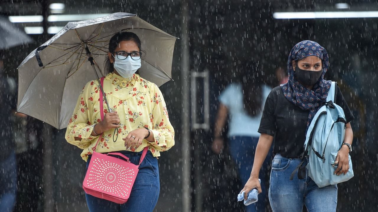 Women walk in rain, in New Delhi. Credit: PTI Photo