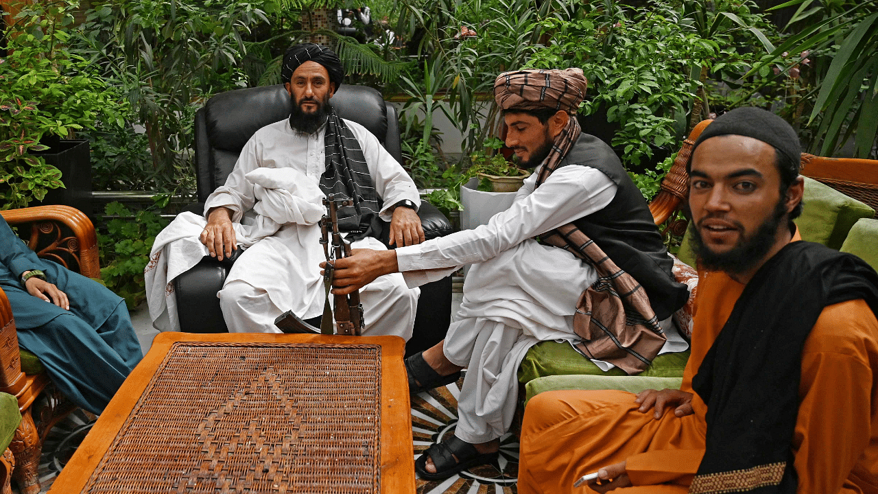 Taliban fighters sit in the greenhouse yard at the home of the Afghan warlord Abdul Rashid Dostum. Credit: AFP Photo