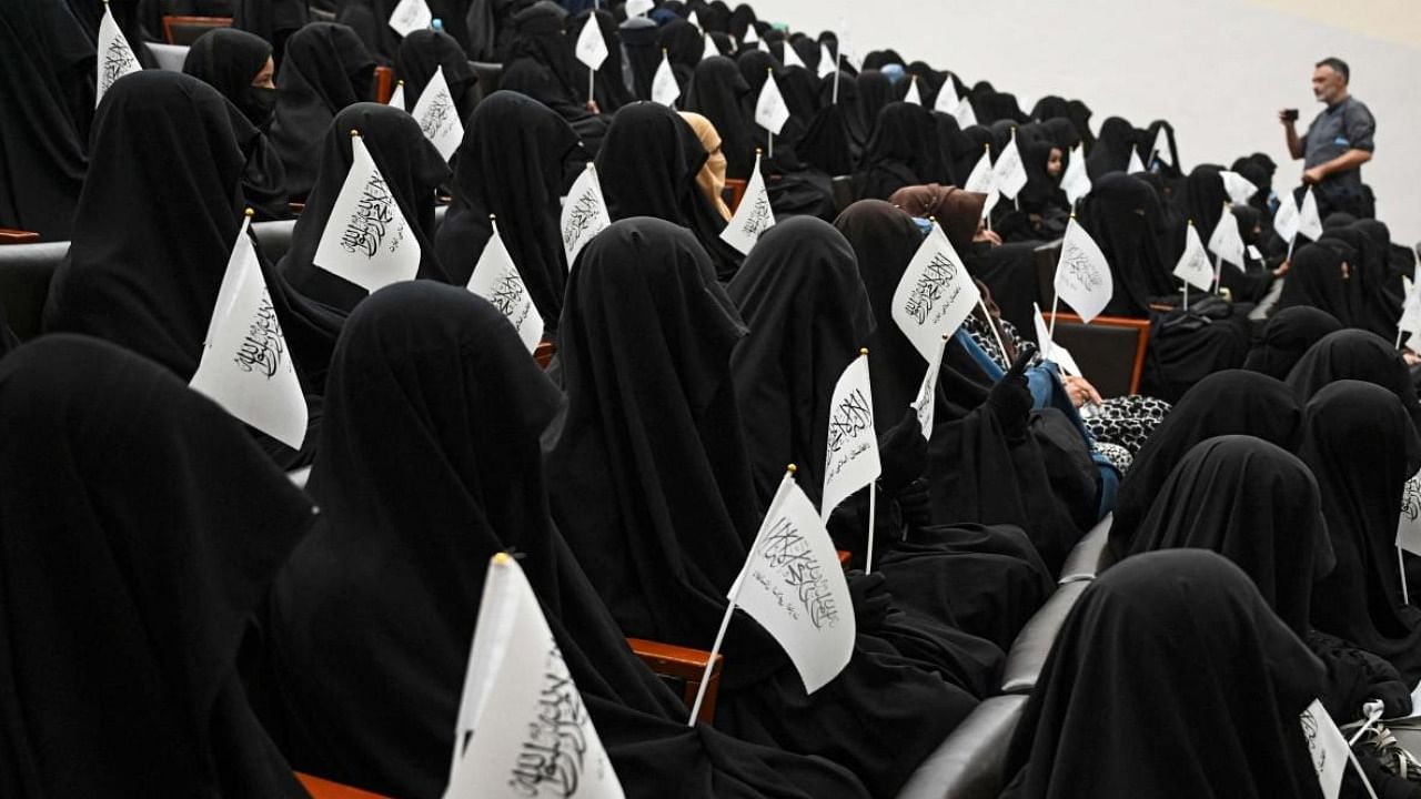 Veiled students hold Taliban flags as they listen to a speaker before a pro-Taliban rally at the Shaheed Rabbani Education University in Kabul. Credit: AFP Photo