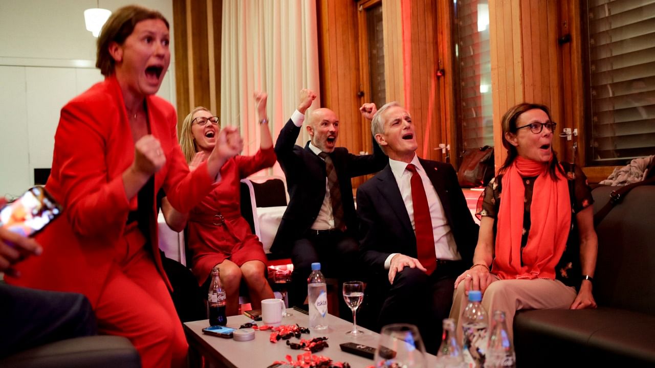 orway's Labor leader Jonas Gahr Store (2nd R) cheers after seeing the exit poll results of the Labor Party's election event in Folkets Hus, in Oslo, during the 2021 Norwegian parliamentary elections. Credit: AFP Photo