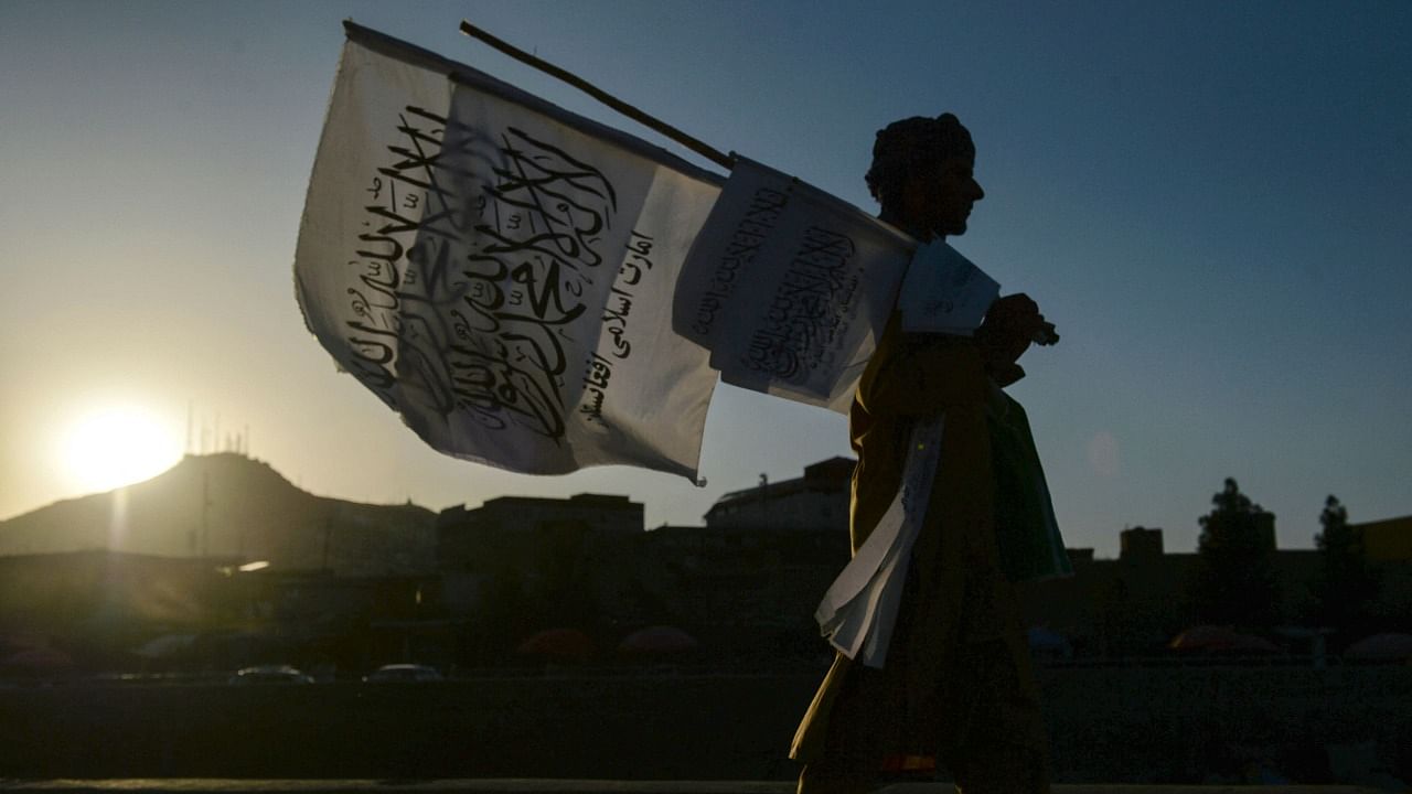 A man selling Taliban flags walks along a street in Kabul on September 15, 2021. Credit: AFP Photo