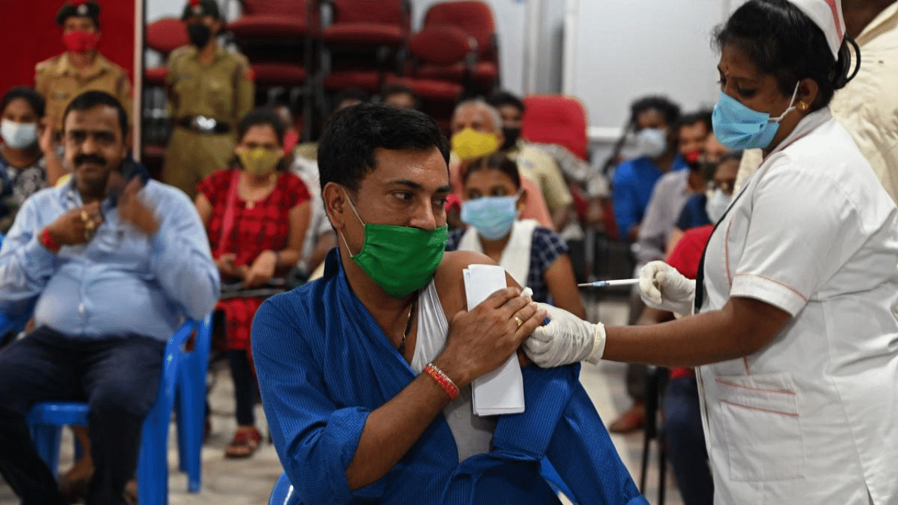 A health worker inoculates a man with a dose of vaccine at a vaccination camp in Chennai. Credit: AFP Photo