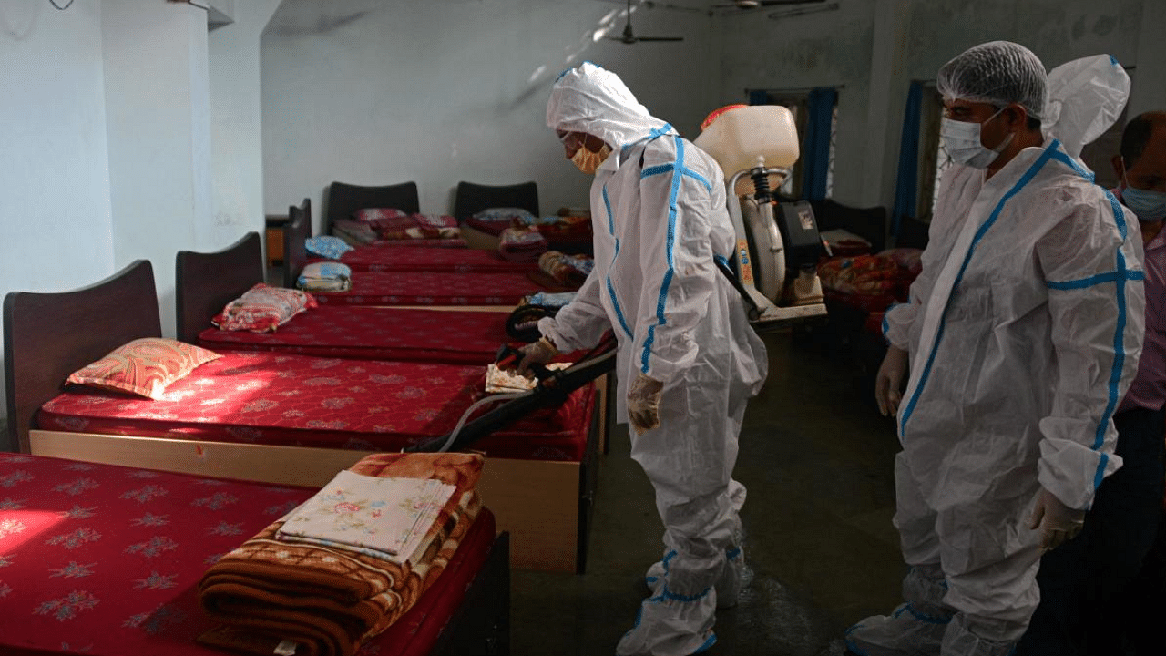 A fire department personnel wearing protective gear sprays disinfectant at a government hostel premises amid coronavirus pandemic in Siliguri, West Bengal. Credit: AFP Photo