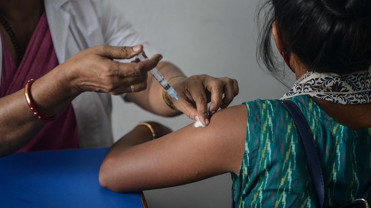 A health worker inoculates a student of Siliguri women's college with a dose of Covishield vaccine against the Covid-19 coronavirus at a vaccination camp in Siliguri on September 13, 2021. Credit: AFP Photo