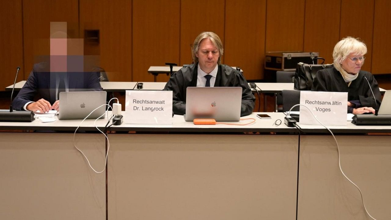 One of four former Volkswagen (VW) executives (L) sits next to his lawyers Marc Langrock (C) and Annette Voges (R) before his trial. Credit: AFP Photo