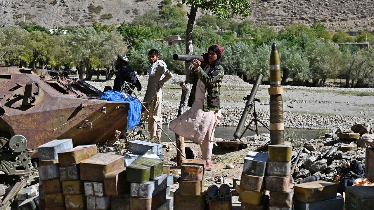 Taliban fighters stand next to ammunition along a road in Malaspa area, Bazark district, Panjshir. Credit: AFP Photo