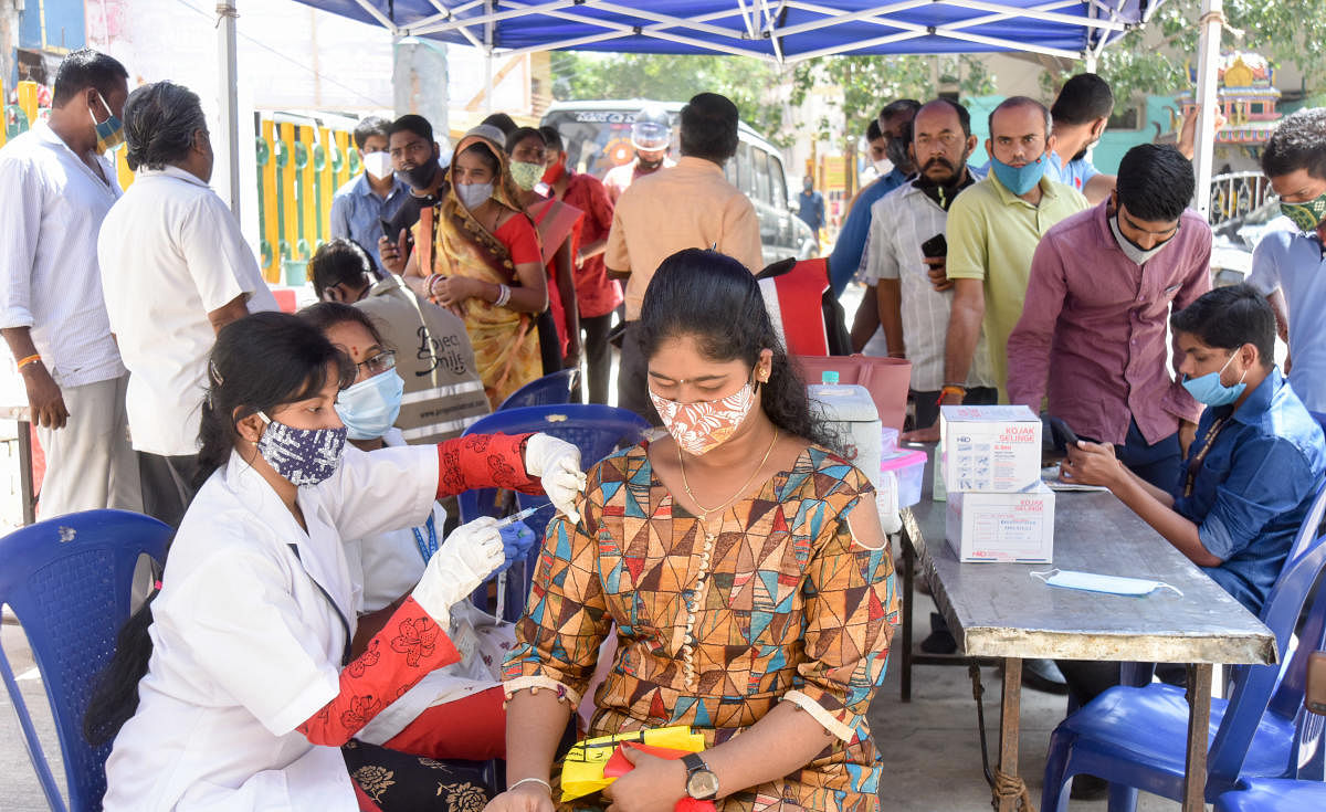 A woman receives the Covid jab at a vaccine booth set up at the Sri Dharmaraya Swamy Temple in Nagarathpet  on Friday. Credit: DH Photo