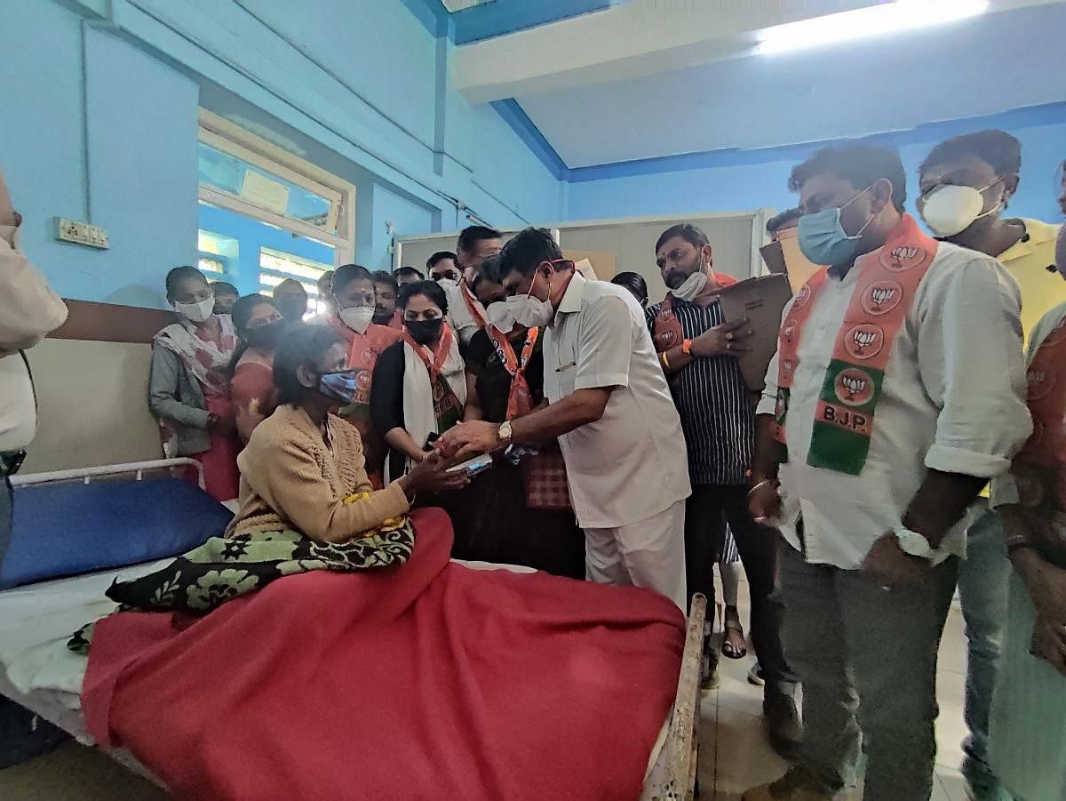 MLA M P Appachu Ranjan distributes fruits to a patient in Madikeri.