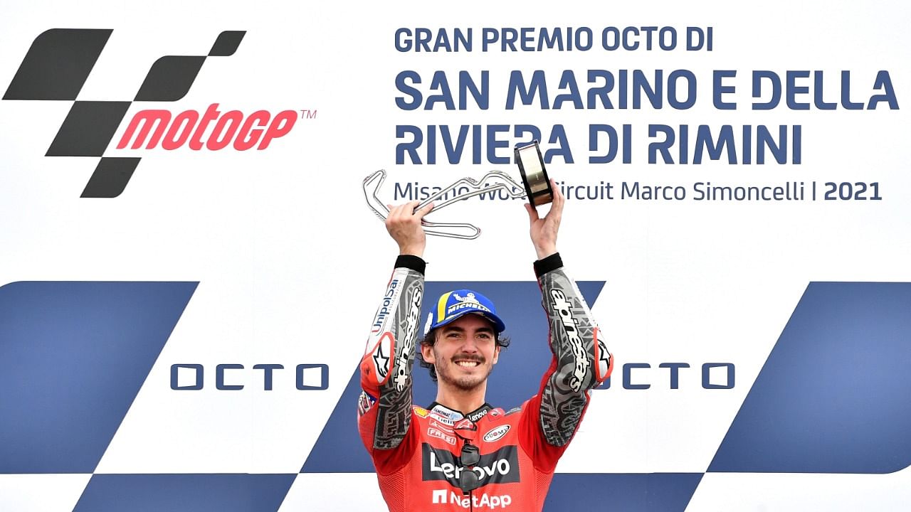 Bagnaia celebrates with the trophy on the podium. Credit: Reuters Photo