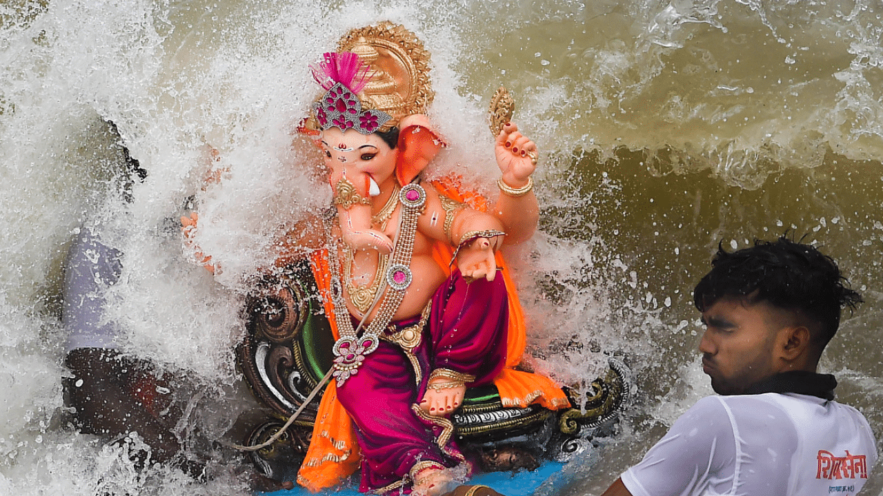 A volunteer immerses an idol of Lord Ganesha in the Arabian Sea, in Mumbai. Credit: PTI Photo