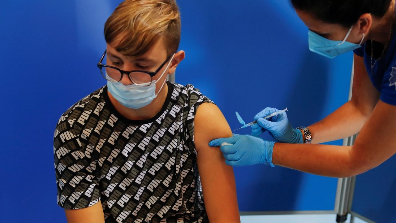 A teenager receives the first dose of the Pfizer-BioNTech "Comirnaty" vaccine against Covid-19. Credit: Reuters File Photo