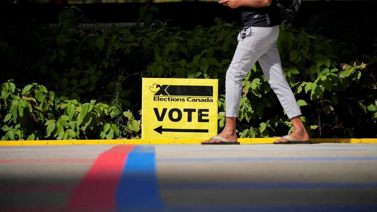 A man walks by an Elections Canada sign at a polling station during the Canada's federal election, in Toronto, Ontario. Credit: Reuters photo