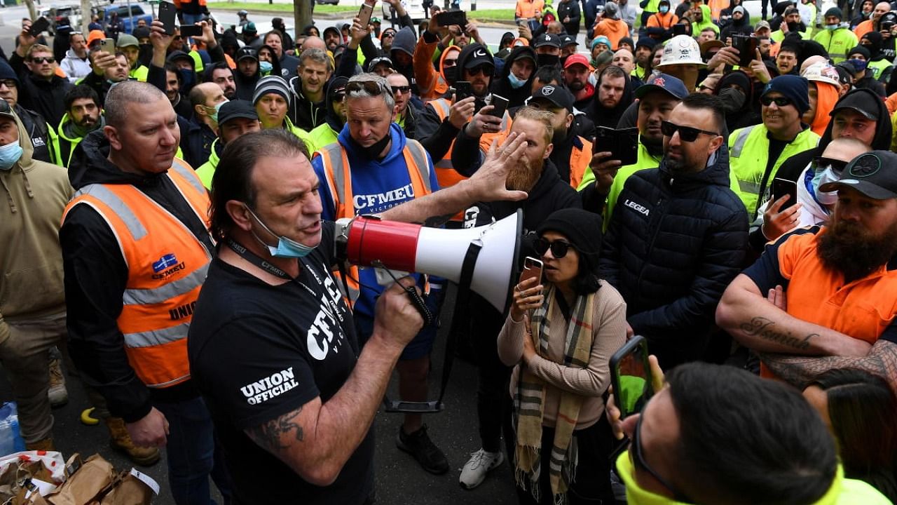 A unionist addresses construction workers protesting work-related coronavirus restrictions at Construction, Forestry, Maritime, Mining and Energy Union (CFMEU) headquarters in Melbourne. Credit: Reuters photo