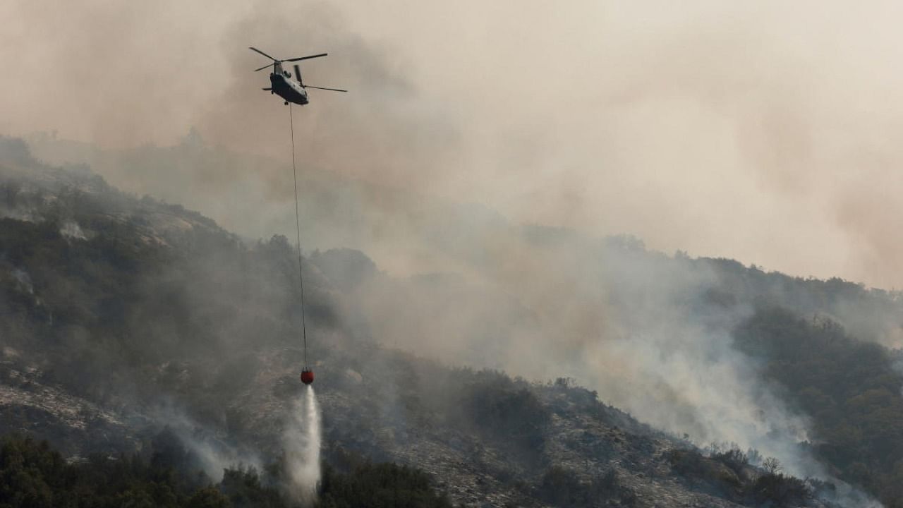 A firefighting helicopter drops water on hotspots burning in the KNP Complex fire, at Sequoia National Park in Tulare County, California. Credit: Reuters photo