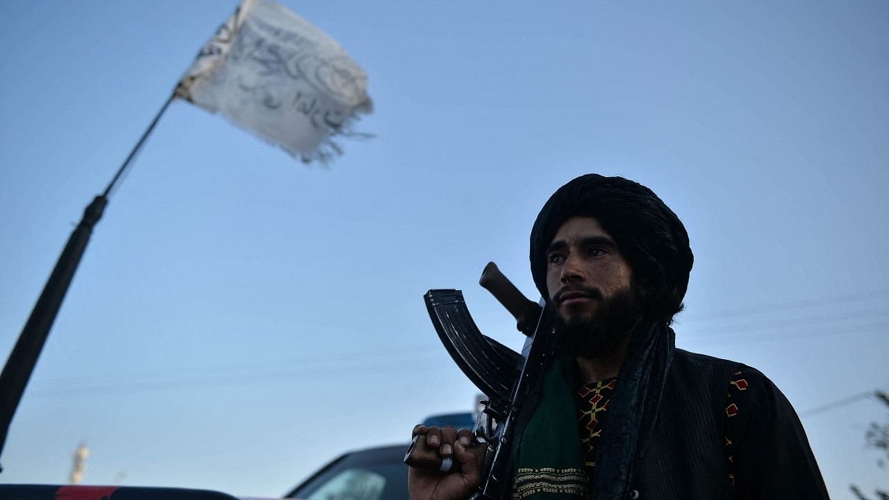 A Taliban fighter stands along a road in Herat. Credit: AFP Photo