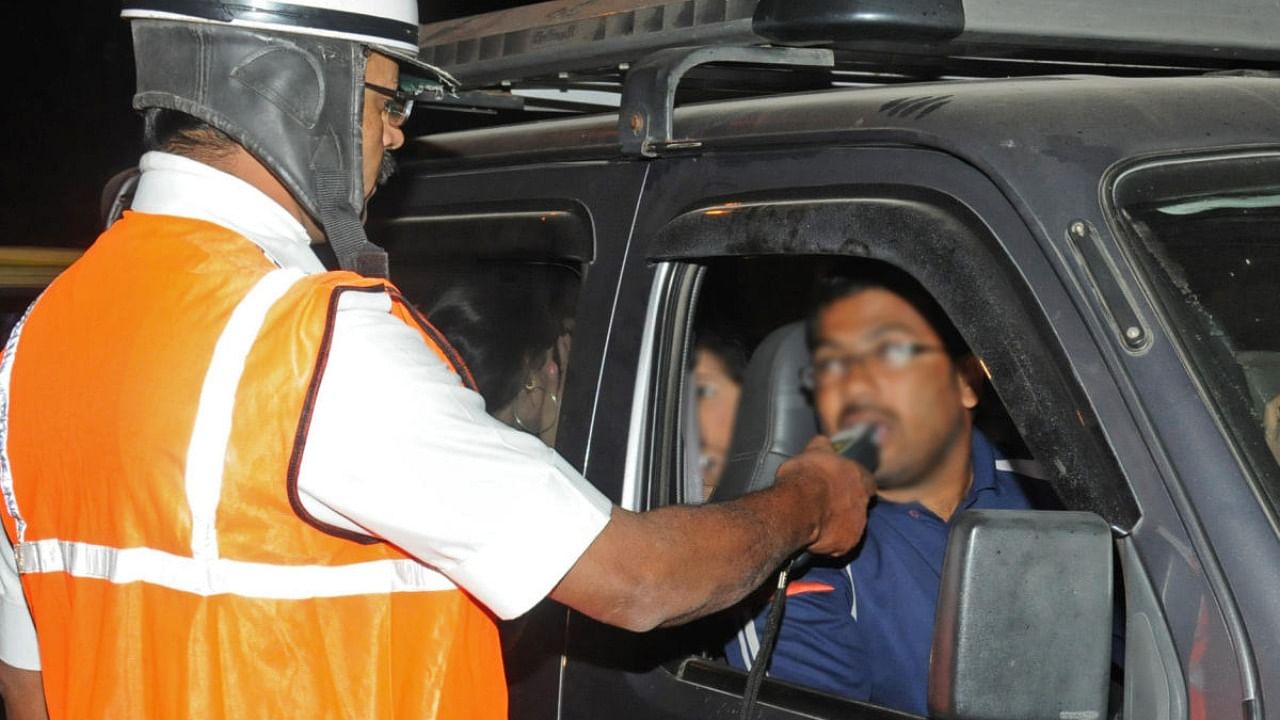 A traffic cop takes a motorist’s breathalyser test during a drive against drink-driving. Credit: DH file photo