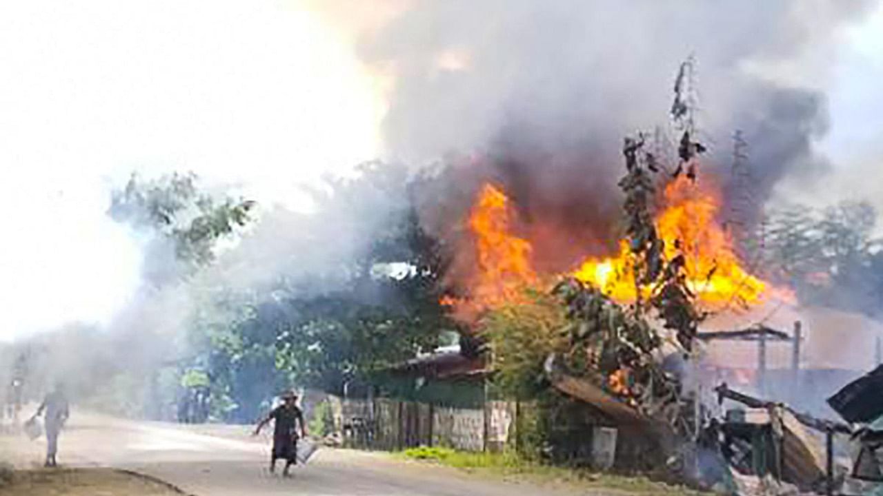 This handout taken on September 10, 2021 and received courtesy of an anonymous source on September 18 shows people attempting to extinguish a fire as houses burn in Namg Kar village in Magwe region's Gangaw township, as fighting continues between the Myanmar military and protesters against the military coup. Credit: AFP Photo