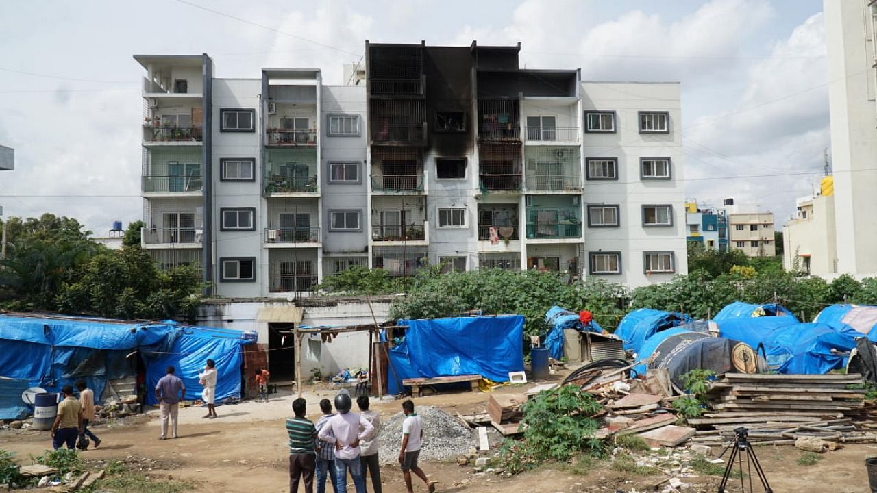 The Ashrith Aspire apartment complex in Begur, a day after a fire erupted in Apartment 210, killing two people. Photo taken from migrant camp on south side of the building. Credit: DH Photo