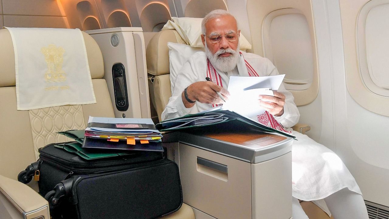 Prime Minister Narendra Modi works on his way to US. Credit: Twitter Photo/@narendramodi