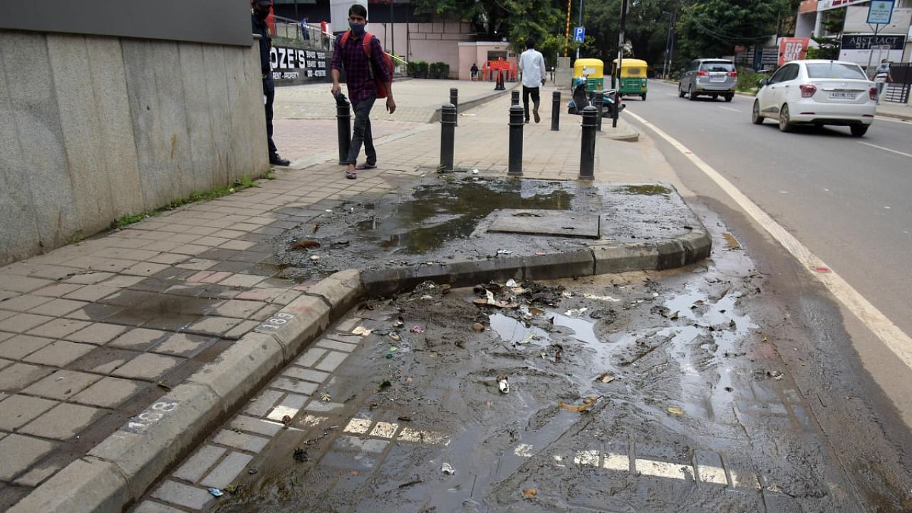Drain water overflows on the TenderSURE footpath and spilt onto Cunningham Road in Bengaluru in July. Credit: DH Photo