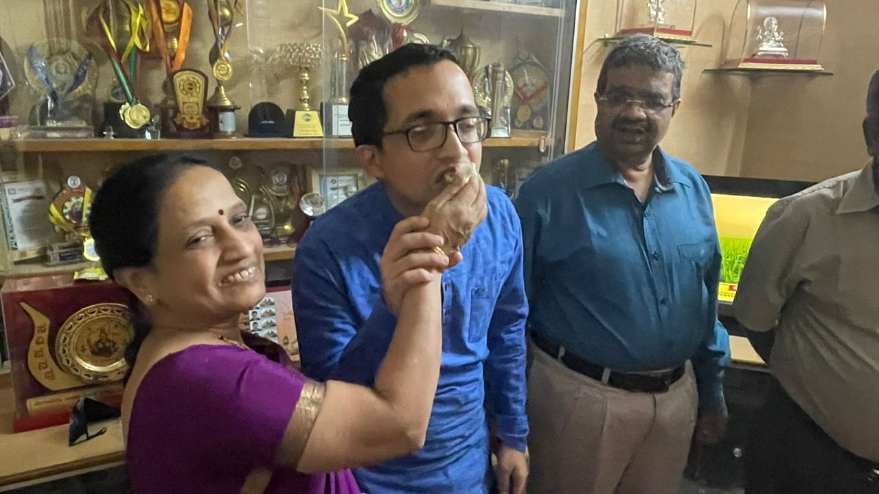 Akshay Simha, who secured 77th rank in the civil services exam, is offered sweets by his parents in Bengaluru. Credit: DH Photo