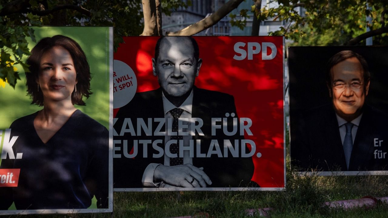 Billboards with election campaign posters showing the three chancellor candidates in the September 26 federal election, (L-R) co-leader of Germany's Greens (Die Gruenen) Annalena Baerbock, German Finance Minister and Vice-Chancellor of the Social Democratic SPD Party Olaf Scholz and Christian Democratic Union CDU leader Armin Laschet are seen in Berlin on September 25, 2021. Credit: AFP Photo