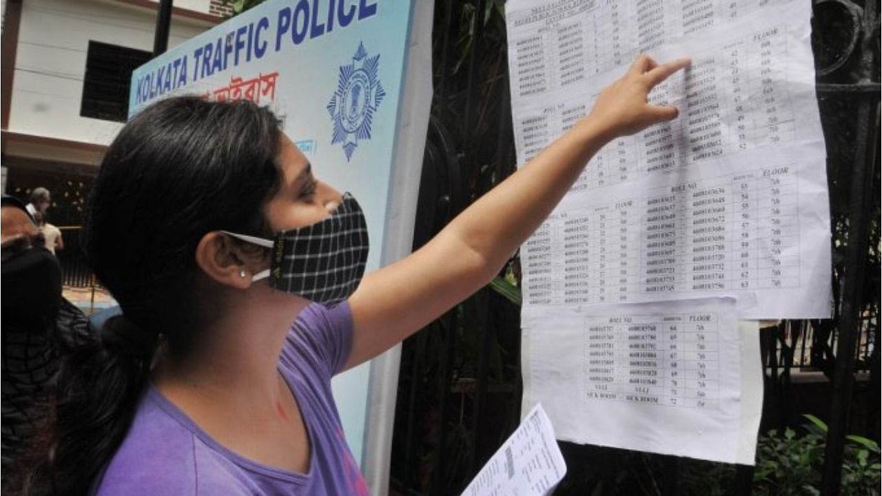 An aspirant looks for her seat number before appearing in National Eligibility cum Entrance Test-2021 (NEET) at an examination centre in Kolkata. Credit: PTI File Photo