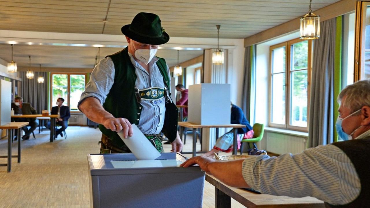 A casts his ballot at a polling station during general elections in Bayrischzell, southern Germany. Credit: AFP Photo