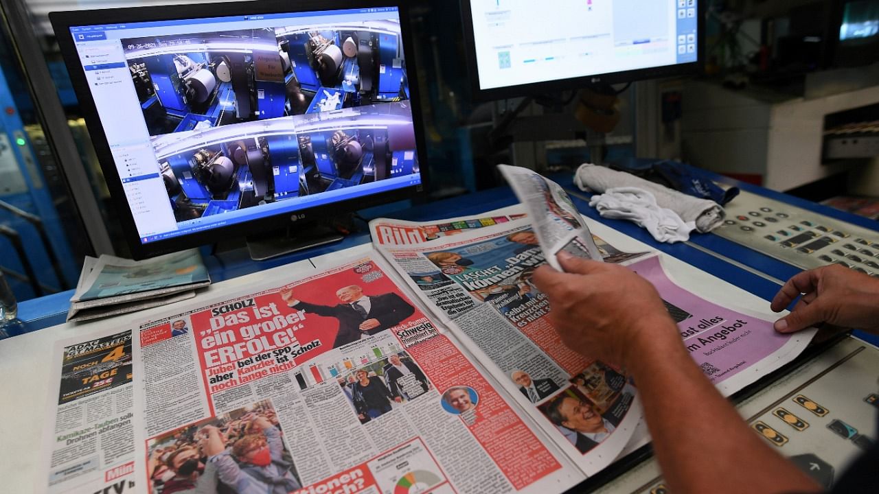 A worker checks a printed edition of Bild newspaper that shows candidate for chancellor Olaf Scholz, of Social Democratic Party (SPD), after the first exit polls for the general elections in Berlin, Germany, September 26, 2021. Credit: Reuters Photo