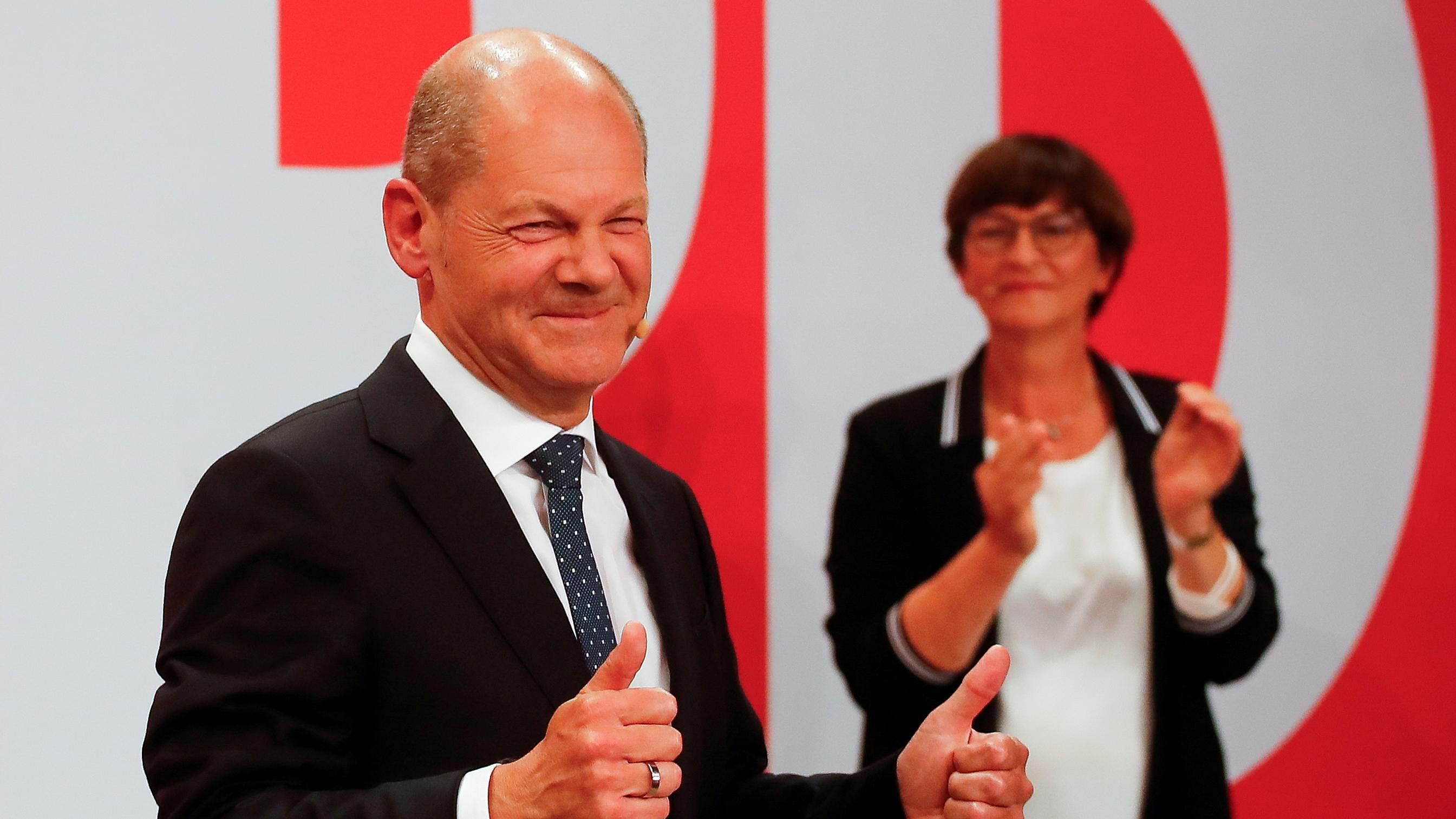Social Democratic Party (SPD) leader and top candidate for chancellor Olaf Scholz and party co-leader Saskia Esken react after first exit polls for the general elections in Berlin. Credit: Reuters Photo