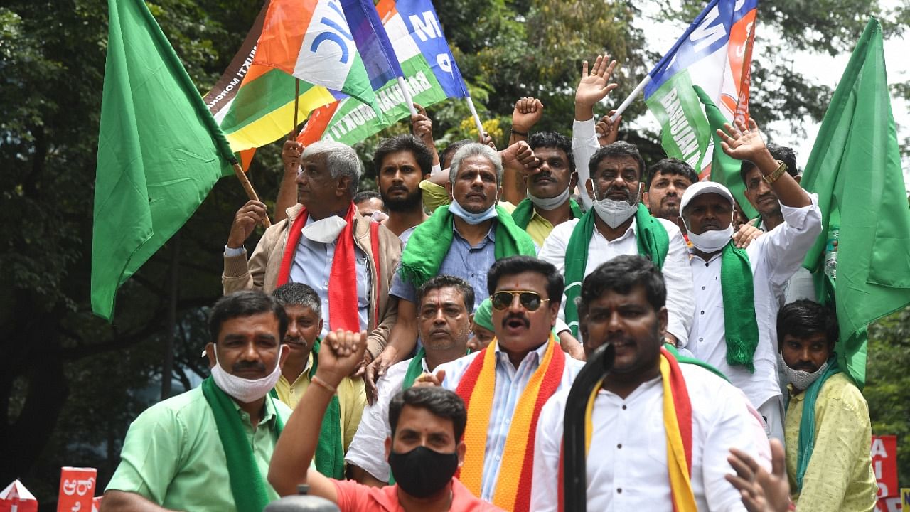 Farmers, activists from various Kannada organisation and Trade Union members raise slogans during their 'Bharat Bandh' against the Central government's three farm reform laws, in Bengaluru on Monday. Credit: DH Photo