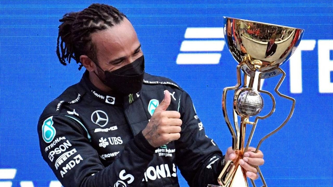 Winner Mercedes' British driver Lewis Hamilton celebrates on the podium after the Formula One Russian Grand Prix at the Sochi Autodrom circuit in Sochi on September 26, 2021. Credit: AFP Photo