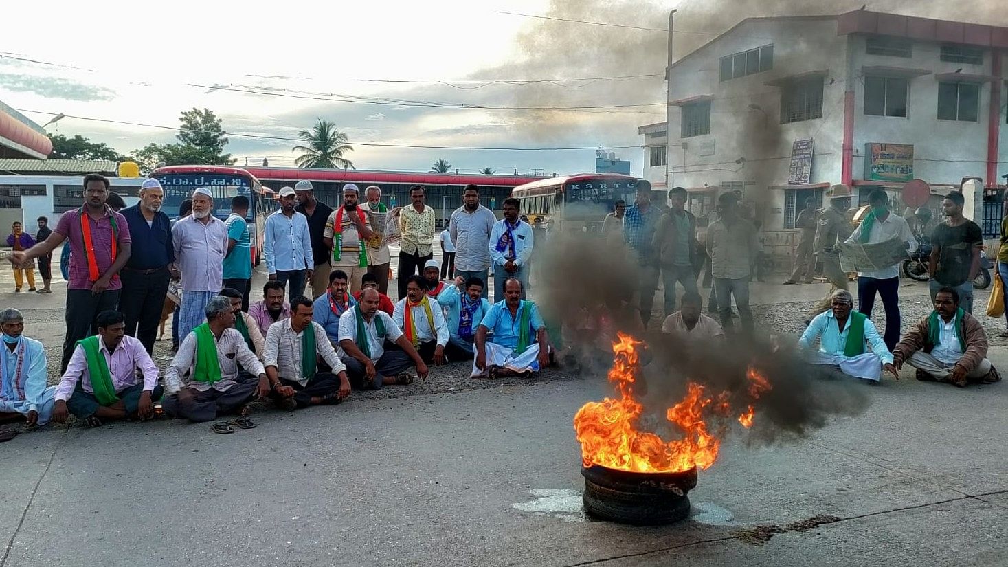 Members of farmers organisations torch tyres during the protest in Chamarajanagar, on Monday. Credit: DH Photo
