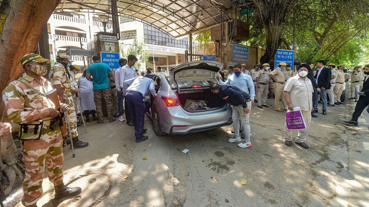 Delhi Police personnel check a vehicle at the Rohini Court, a day after the shooting incident. Credit: PTI File Photo