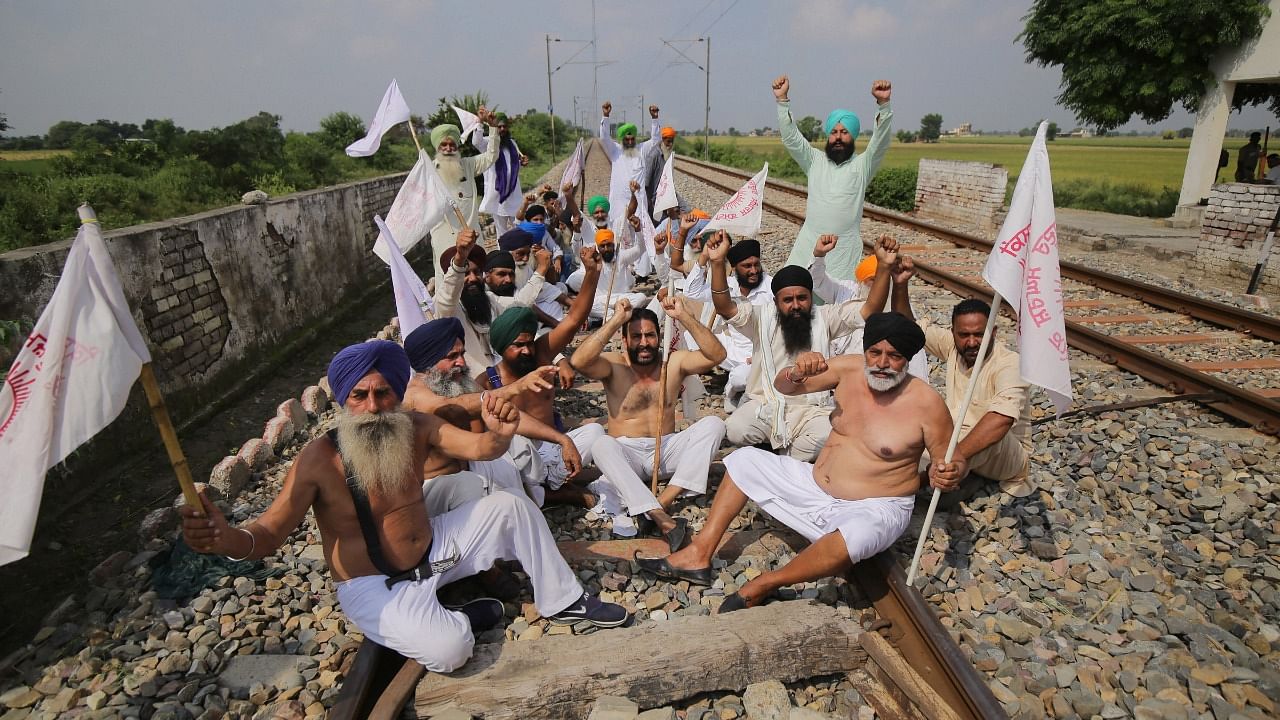 Farmers block the railway tracks during their 'Bharat Bandh' against central government's three farm reform laws, at Devi Dass Pura on the outskirts of Amritsar. Credit: PTI Photo