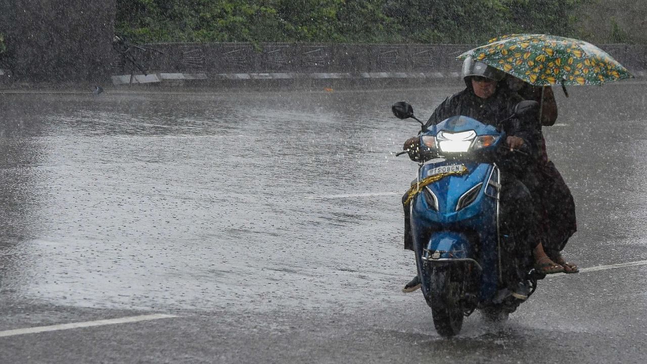 Motorists make their way amid heavy rains along a road. Credit: AFP Photo