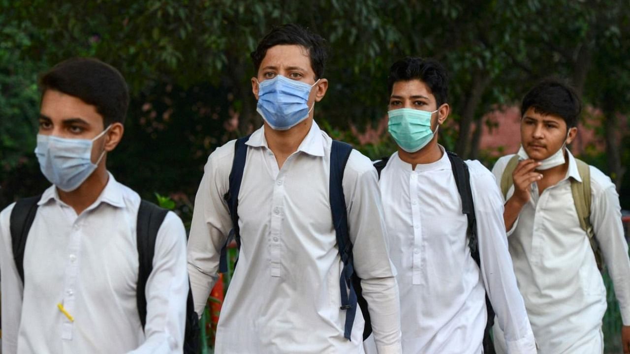 Students wearing facemasks arrive at a school in Peshawar. Credit: AFP Photo