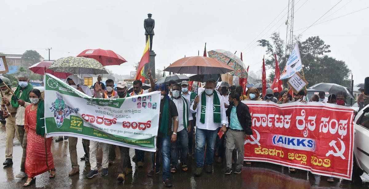 Leaders take part in the protest at General Thimayya Circle in Madikeri, amid the rain, on Monday.