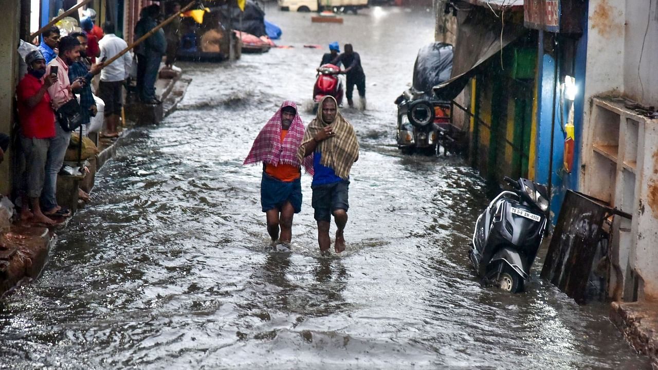 People wade through a waterlogged road following heavy rains at Siddiamber Bazar in Hyderabad. Credit: PTI Photo