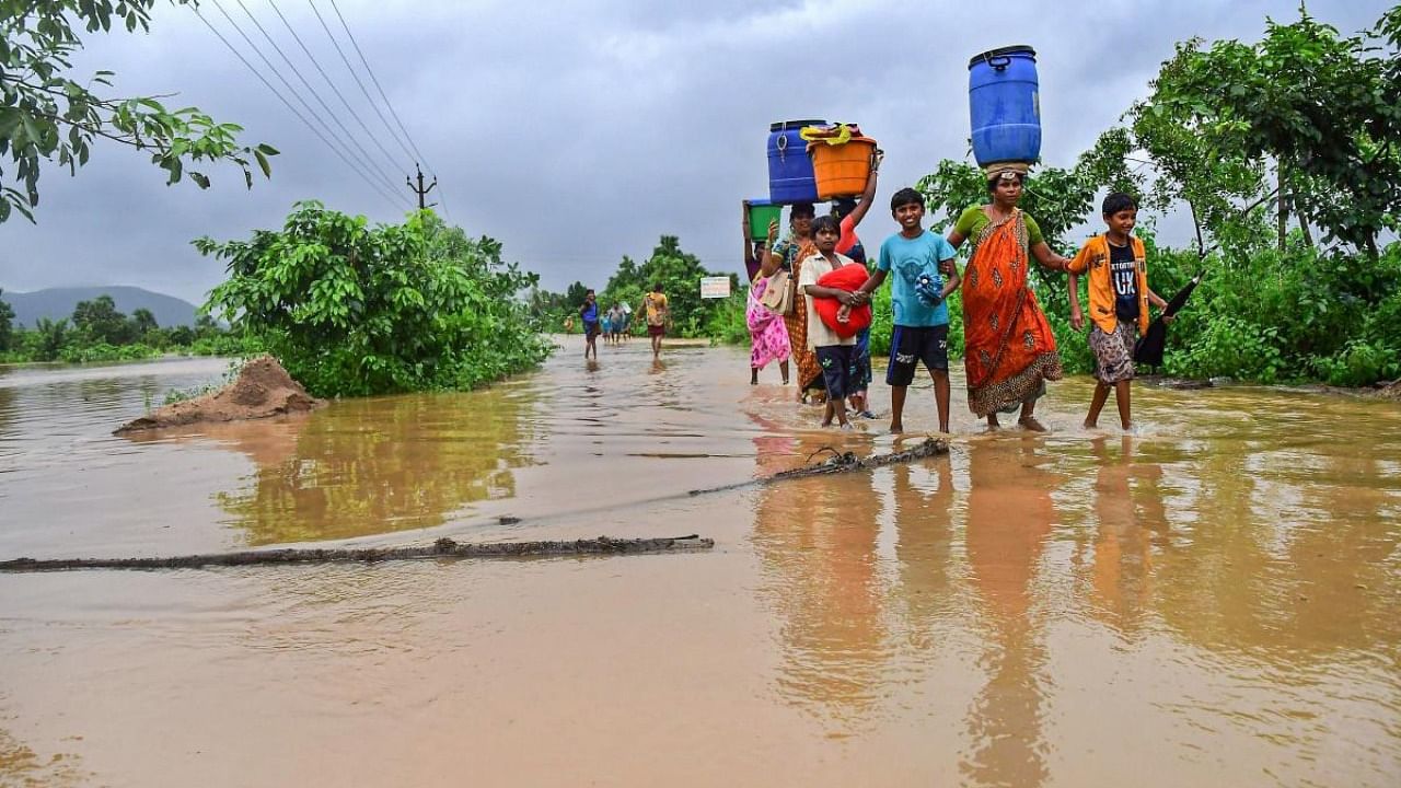 Villagers wade through a flood affected area following heavy rains induced by Cyclone Gulab in Visakhapatnam. Credit: PTI Photo