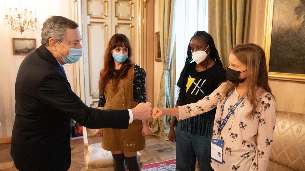 Italy's Prime Minister, Mario Draghi (L) meeting with (From R) Swedish climate activist Greta Thunberg, Ugandan climate activist Vanessa Nakate and Italian climate activist Martina Comparelli on the sidelines of the Pre-COP 26 summit in Milan. Credit: AFP Photo