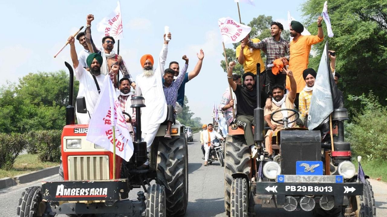 Farmers shout slogans from their tractors during a nationwide strike against the central government's agricultural reforms on the outskirts of Amritsar. Credit: AFP Photo