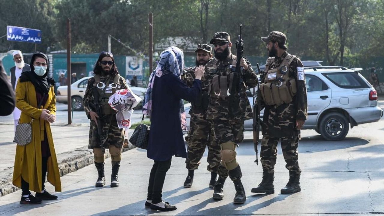 Members of the Taliban special forces stop a woman protestor from continuing a demonstration held outside a school in Kabul. Credit: AFP Photo