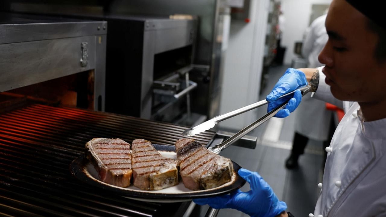 A chef cooks beef steaks at the kitchen of Wolfgang's Steakhouse restaurant, in Beijing. Credit: Reuters Photo